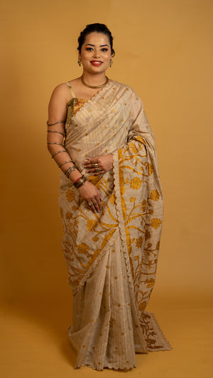 Beige tissue silk saree with golden floral embroidery and scalloped designer border