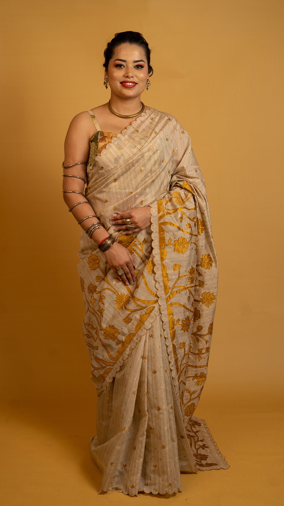 Beige tissue silk saree with golden floral embroidery and scalloped designer border