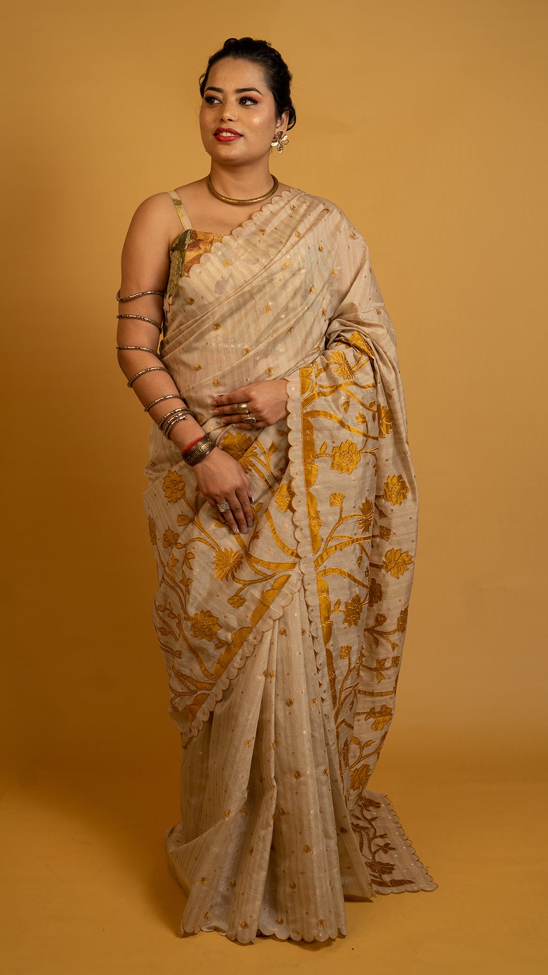 Beige tissue silk saree with golden floral embroidery and scalloped designer border