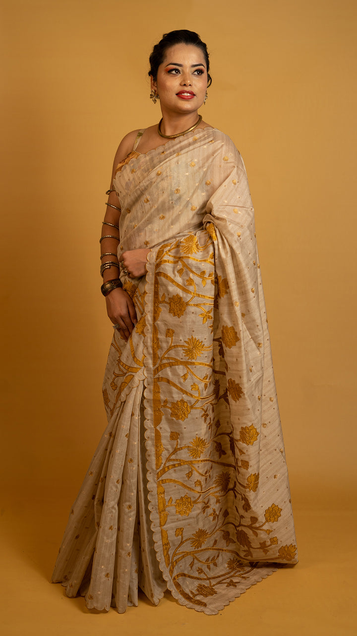 Beige tissue silk saree with golden floral embroidery and scalloped designer border