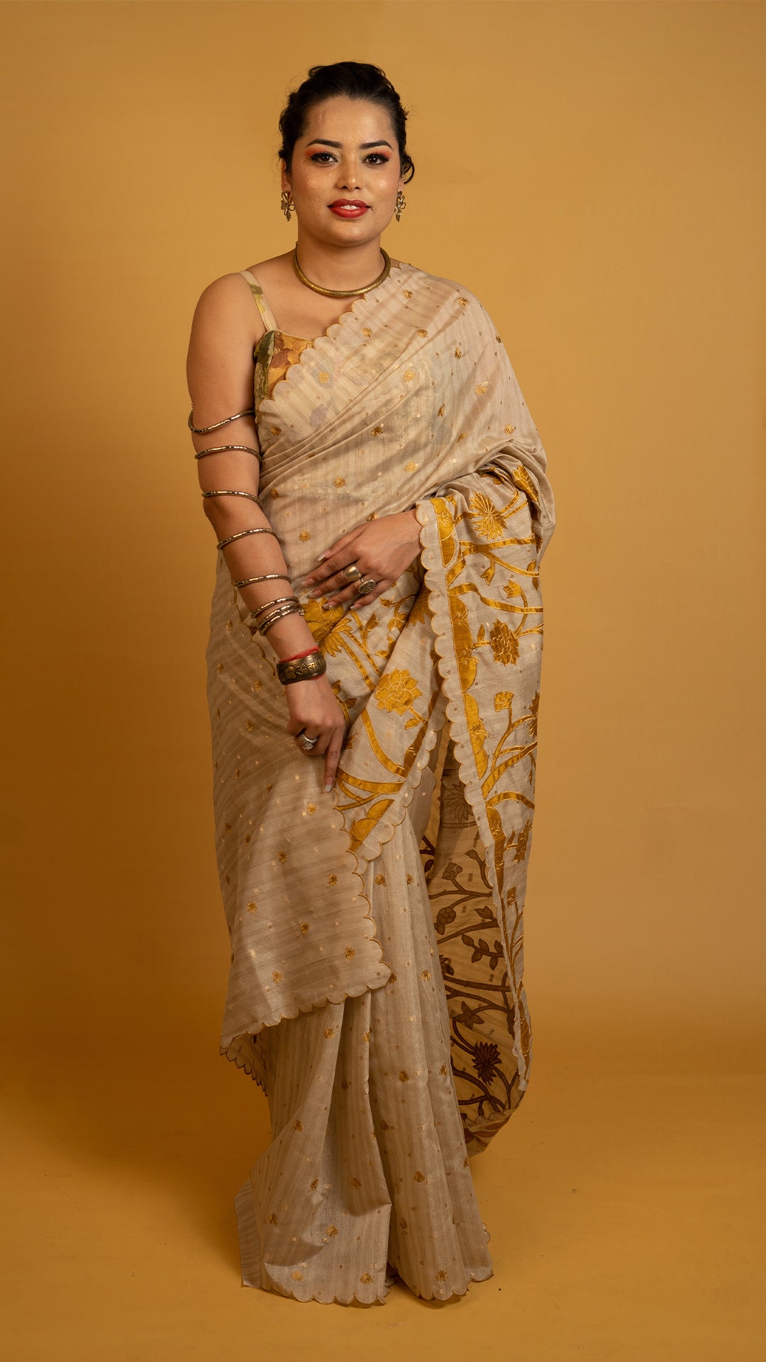 Beige tissue silk saree with golden floral embroidery and scalloped designer border