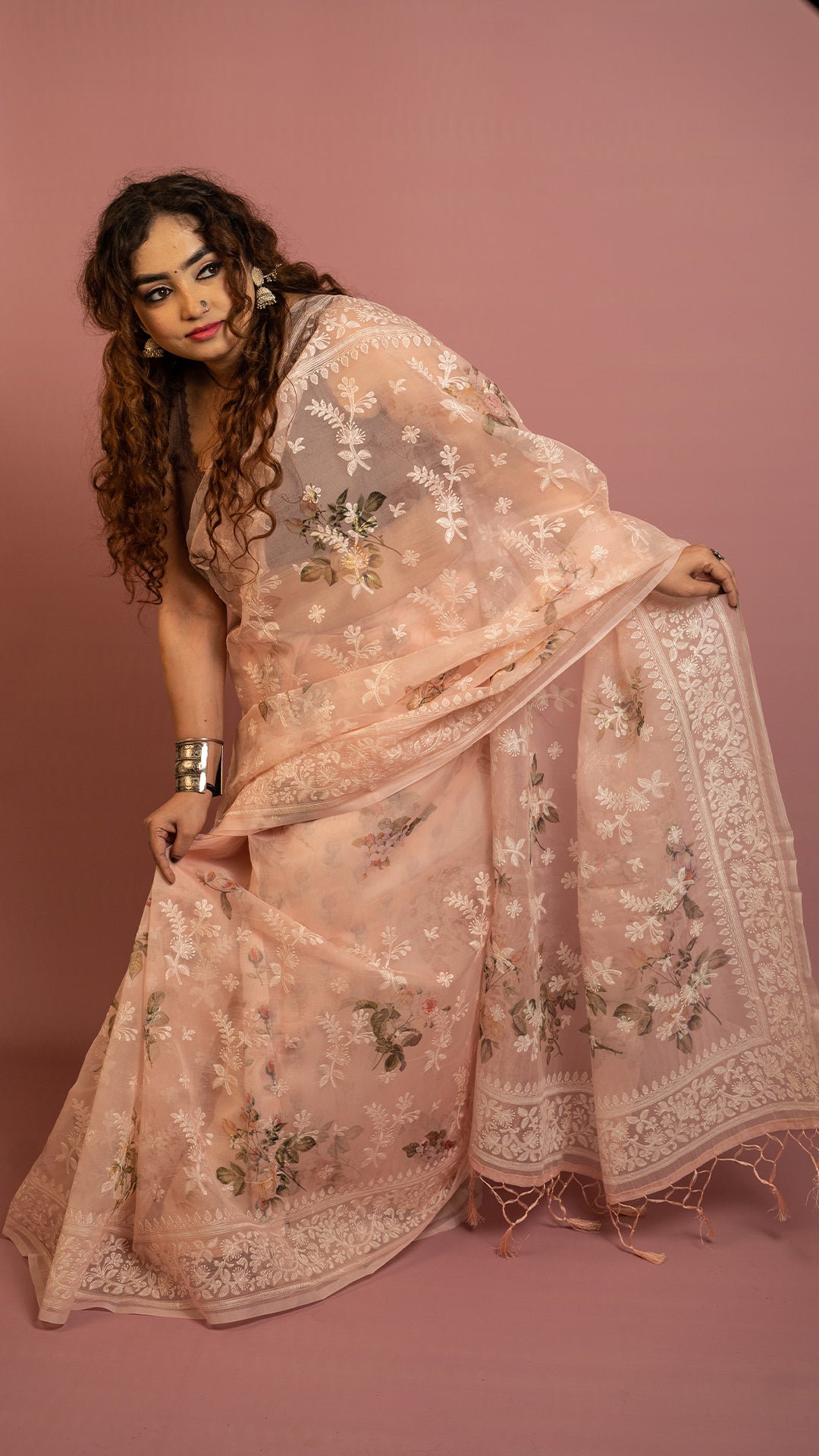 Peach floral embroidered organza saree with elegant border and lightweight sheer fabric