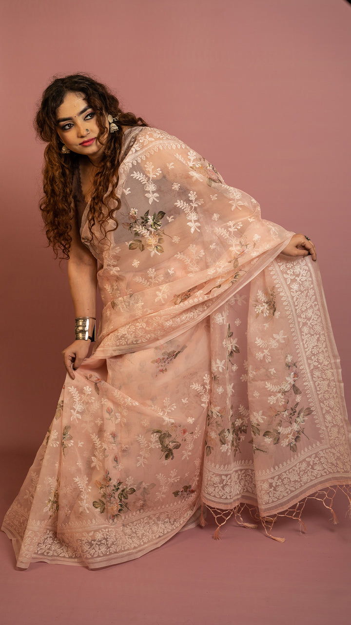 Peach floral embroidered organza saree with elegant border and lightweight sheer fabric