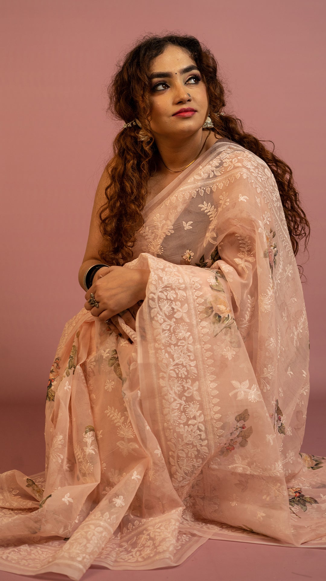 Peach floral embroidered organza saree with elegant border and lightweight sheer fabric