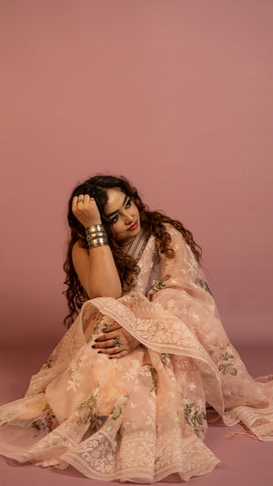 Peach floral embroidered organza saree with elegant border and lightweight sheer fabric