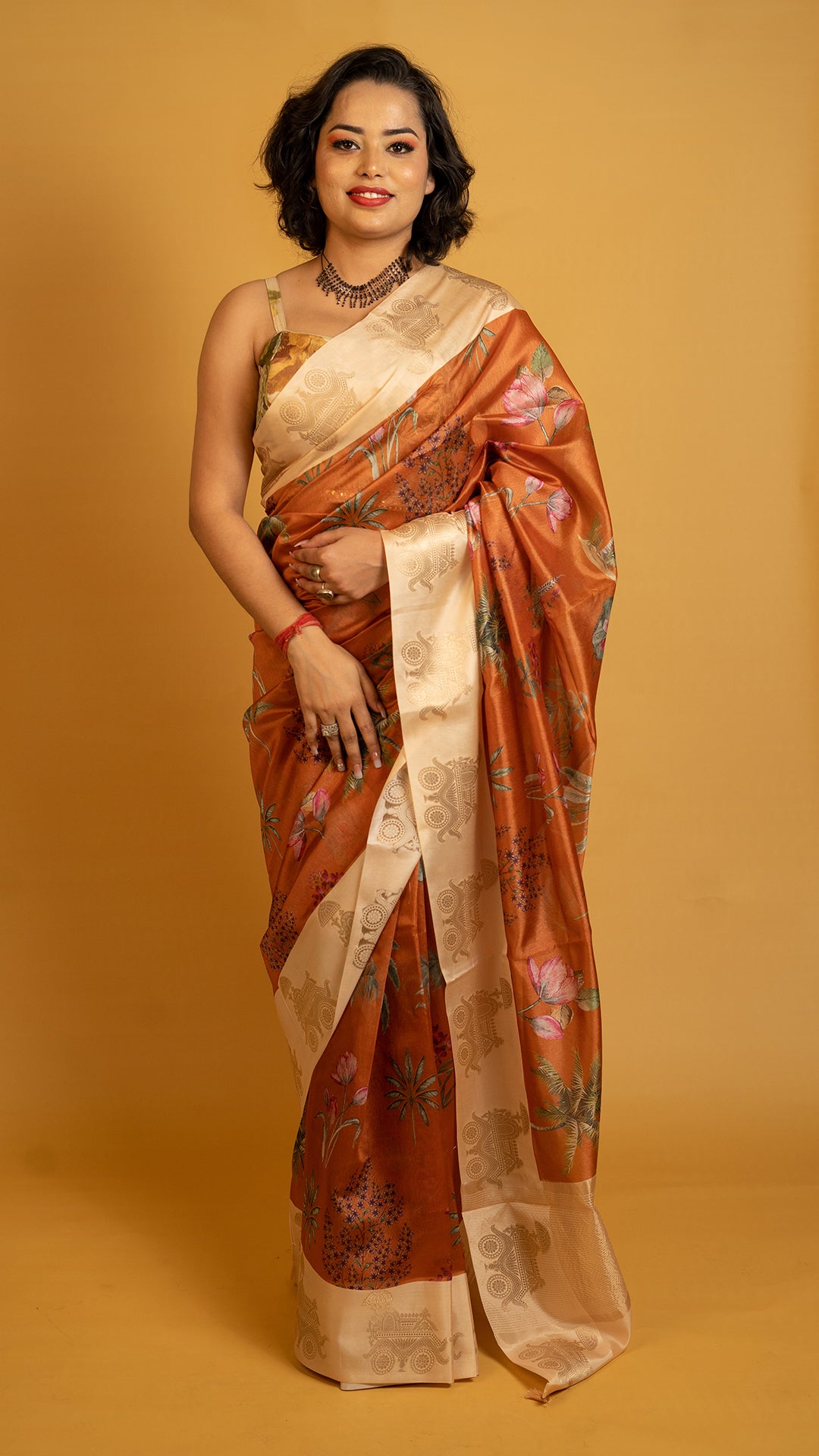 Rust orange silk saree with floral print and cream zari border
